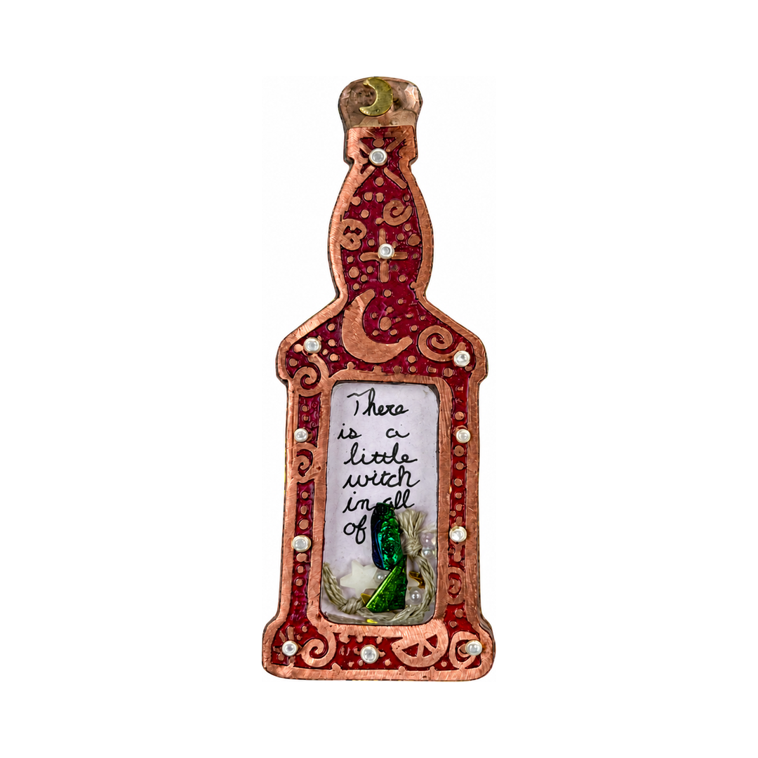 Red and copper potion bottle pin with moon and swirl details, rhinestones, and a window holding a handwritten note and a green crystal